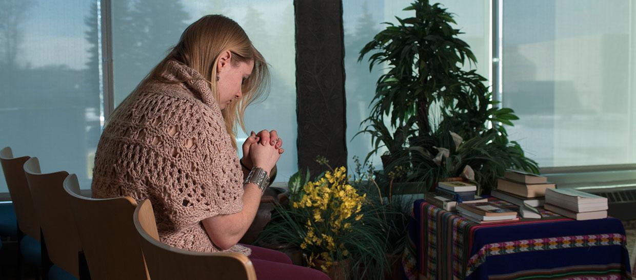 学生 praying in prayer room on campus